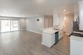 Located at 1538 N Vista St in the heart of Los Angeles, CA, this single-floor unit offers a clean, modern aesthetic with thoughtful finishes throughout. The open-concept living and kitchen area is anchored by light wood-tone flooring and soft grey walls, creating a bright and airy atmosphere. Natural light filters in through vertical-blind covered windows, adding warmth to the generous living space.

The kitchen is a functional highlight, featuring a peninsula with a sleek white quartz countertop and an undermount sink, crisp white shaker cabinetry extending to the ceiling, a mosaic tile backsplash, and a full suite of stainless steel appliances including a gas range, microwave, refrigerator, and dishwasher. Recessed lighting illuminates both the kitchen and living areas effectively.

The bathroom is finished with large-format neutral stone-look wall tiles surrounding a soaking tub and shower combination, paired with a white vanity topped with a marble-look quartz surface and a wide mirror with integrated lighting.

The bedroom is a calm retreat, benefiting from a window overlooking lush greenery, allowing natural light and a connection to the outdoors. Clean walls and consistent flooring carry the cohesive, contemporary design throughout the entire space.