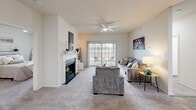 Located in Lake Saint Louis, Missouri, this single-story 2-bedroom, 2-bathroom home offers a thoughtfully designed layout with comfortable living spaces throughout. The open living room serves as the heart of the home, featuring a classic white-mantled fireplace, plush carpeting, a ceiling fan, and sliding glass doors that invite natural light and provide access to an outdoor patio with views of the surrounding area. The adjacent kitchen is well-equipped with white cabinetry, dark speckled countertops, a full suite of white appliances including a dishwasher, and a skylight that brightens the space. A breakfast bar provides casual dining convenience. The spacious primary bedroom features a ceiling fan, natural light from a large window, and plush carpeting, while the second bedroom offers a cozy retreat with a built-in closet. Both bathrooms mirror the home's clean aesthetic, featuring white vanities with matching countertops and wood-look flooring. A dedicated laundry room houses a full-size Whirlpool washer and dryer with wire shelving above for added storage. Additional storage is provided by a walk-in closet with wire shelving. The home's neutral palette and consistent finishes create a bright, cohesive ambiance throughout.