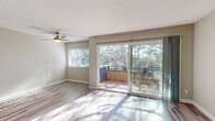 Located in the desirable La Jolla Boulevard corridor of San Diego, this single-floor residence offers a thoughtfully laid-out interior finished with light wood-style flooring throughout. The open living area is spacious and sun-drenched, benefiting from large sliding glass doors that lead to a private balcony overlooking mature trees — a serene, nature-framed outlook that fills the interior with natural light. A ceiling fan adds both function and character to the living space. The kitchen is efficiently designed, featuring white cabinetry with brushed nickel hardware, granite-style countertops, a built-in microwave, electric range, and refrigerator — offering ample storage and workspace. The bedroom areas are well-proportioned, with one featuring a mirrored sliding-door closet and another with a reach-in closet, both benefiting from the same consistent light flooring. An entry closet provides additional storage near the front door. The bathroom is cleanly appointed with a marble-style vanity countertop, white cabinetry, a tub-shower combination, and matching light flooring. Neutral wall tones and textured ceilings carry throughout, creating a cohesive and move-in-ready aesthetic in this well-located San Diego residence.