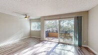 Located in the desirable La Jolla Boulevard corridor of San Diego, this single-floor residence offers a thoughtfully laid-out interior finished with light wood-style flooring throughout. The open living area is spacious and sun-drenched, benefiting from large sliding glass doors that lead to a private balcony overlooking mature trees — a serene, nature-framed outlook that fills the interior with natural light. A ceiling fan adds both function and character to the living space. The kitchen is efficiently designed, featuring white cabinetry with brushed nickel hardware, granite-style countertops, a built-in microwave, electric range, and refrigerator — offering ample storage and workspace. The bedroom areas are well-proportioned, with one featuring a mirrored sliding-door closet and another with a reach-in closet, both benefiting from the same consistent light flooring. An entry closet provides additional storage near the front door. The bathroom is cleanly appointed with a marble-style vanity countertop, white cabinetry, a tub-shower combination, and matching light flooring. Neutral wall tones and textured ceilings carry throughout, creating a cohesive and move-in-ready aesthetic in this well-located San Diego residence.