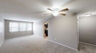 Located at 950 Village Green Ln in Waterford, MI, this single-floor residence offers a practical and comfortable layout with two bedrooms, a den, and two bathrooms. The living room serves as the heart of the home, featuring plush carpeting, a ceiling fan with light fixture, and a large window with vertical blinds that allows natural light to fill the space. It connects seamlessly to the kitchen, which is outfitted with dark wood cabinetry, granite-style countertops, stainless steel appliances including a refrigerator and dishwasher, and wood-look flooring that adds warmth to the room. The generously sized primary bedroom offers ample room and includes a walk-in closet with built-in shelving. The second bedroom is carpeted and features a window with outdoor views. The den is a bright, versatile space with wood-look flooring and a window, suitable as a home office or additional living area. Both bathrooms are well-appointed with dark wood vanities, granite-style countertops, and large mirrors. One bathroom includes a full tub and shower combination. A connecting hallway ties the layout together efficiently, making this a well-organized and functional home.