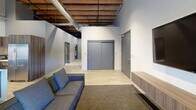 Located at 1011 W First Ave in the heart of downtown Spokane, this 2-bedroom, 1-bathroom loft masterfully combines industrial heritage with contemporary design. The open-concept kitchen and living area serves as the centerpiece of the space, boasting soaring ceilings with exposed wood beams and visible ductwork that honor the building's history. The chef's kitchen features sleek wood-grain cabinetry with under-cabinet lighting, a mosaic tile backsplash, stainless steel appliances, and a generous waterfall-edge island with seating — all bathed in natural light. The living area showcases original exposed brick walls and large windows offering urban views of the Spokane skyline. Light wood-style flooring runs throughout the common areas, adding warmth to the industrial aesthetic. Both bedrooms offer plush carpeting, recessed lighting, and sliding barn-style closet doors, with exposed brick accents lending texture and character. The bathroom is elegantly appointed with large-format stone tiles, a frameless glass walk-in shower with a built-in bench, a floating wood vanity, and modern lighting. An in-unit laundry room with a full-size washer and dryer adds everyday convenience. This loft delivers a compelling blend of historic charm and refined urban living.