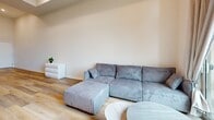 Located at 748 Irolo St in Los Angeles' Koreatown neighborhood, this two-bedroom, two-bathroom single-floor unit offers a clean, modern aesthetic throughout. Wood-look flooring runs continuously across all rooms, complementing a neutral palette of whites and warm grays that creates a bright, cohesive atmosphere.

The living room is a standout space, featuring notably high ceilings and a large floor-to-ceiling window with access to a private balcony overlooking city views. This generous influx of natural light enhances the open, airy feel of the room.

The kitchen is well-appointed with gray shaker-style cabinetry, white quartz countertops, a wall-mounted range hood, and a full suite of stainless steel appliances including a gas range, dishwasher, and French door refrigerator. The unit notably includes two kitchens, offering added flexibility.

Both bedrooms feature elevated ceilings and wood-look flooring. The primary bedroom includes a window with natural light and a closet with sliding doors. The second bedroom is compact yet functional.

Both bathrooms are identically finished with gray vanities, backlit mirrors, white quartz countertops, and full tub-shower combinations, maintaining a consistent, contemporary style throughout the unit.