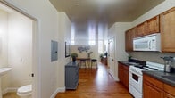 Located at 1841 N 3rd St in Harrisburg, Pennsylvania, this single-floor unit offers a well-organized, open layout that maximizes functionality and comfort throughout. Warm hardwood flooring runs continuously across the main living areas, lending a cohesive and inviting character to the space.

The kitchen is well-appointed with rich honey-toned wood cabinetry, dark countertops, and white appliances including a range, microwave, and refrigerator. A practical layout ensures ample storage and counter space, making it suitable for everyday cooking needs.

Adjacent to the kitchen, an open dining and living area provides a versatile gathering space. Natural light filters in through windows positioned at an elevated height, brightening the room while maintaining privacy. The layout accommodates both a dining setup and flexible living arrangements with ease.

The bedroom is a standout feature, offering generous proportions and multiple large windows that flood the room with abundant natural light and views of the surrounding neighborhood. The bright, airy atmosphere of this room creates a calm and restful retreat.

The bathroom is clean and simply designed, featuring tile flooring, a pedestal sink, and a well-lit vanity mirror, offering a functional and tidy space. An electrical panel is conveniently accessible within the unit. Overall, this space presents a practical and comfortable living environment in a central Harrisburg location.