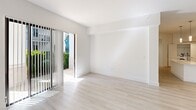 This contemporary single-story residence in Boca Raton, FL offers 1,260 square feet of thoughtfully designed living space. The home features four bedrooms, including a 140 square foot primary suite, and two full bathrooms. The heart of the home is an open-concept kitchen and living area, showcasing a sleek, white kitchen with stainless steel appliances, ample cabinetry, and a functional layout. Light wood-look flooring flows throughout, complementing the crisp white walls and creating a bright, airy atmosphere. Large windows and sliding glass doors in the living areas and bedrooms invite natural light and provide views of the surrounding greenery. The bathrooms boast modern fixtures and tiled surfaces, while the bedrooms offer spacious closets with wire shelving systems for optimal organization. Additional amenities include a dedicated laundry area and recessed lighting throughout. The property's clean lines, neutral color palette, and contemporary finishes make it an ideal canvas for various decorating styles, appealing to those seeking a move-in ready, low-maintenance home in a desirable Florida location.