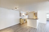 Located at 100 Hilltop Dr in Walpole, MA, this two-bedroom, two-bathroom unit offers a practical and well-organized single-level layout. Light wood-style flooring runs consistently throughout, lending a clean, cohesive feel to the entire space. The galley-style kitchen is well-equipped with light wood cabinetry, laminate countertops, a double sink, and white appliances including a range, microwave, refrigerator, and dishwasher. Track lighting illuminates the kitchen, which opens via a breakfast bar into the adjoining living area — a bright, open space with a large window that allows natural light to fill the room. Both bedrooms feature wood-style flooring, neutral walls, textured ceilings, and individual windows with blinds that bring in natural light. The spacious primary bedroom offers ample room for furnishings. The two bathrooms are finished with light wood cabinetry and warm-toned countertops; one features a tiled tub-shower combination with chrome fixtures. A dedicated closet provides additional storage. Throughout, the unit presents a clean, neutral palette of white walls and light flooring, creating a bright and functional living environment.