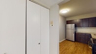 Located at 8 Huntington Circle in Naperville, IL, this single-floor unit offers a well-organized layout that balances functional living spaces with updated finishes throughout. The kitchen serves as a standout feature, showcasing rich dark wood cabinetry with sleek hardware, granite countertops, a classic white subway tile backsplash, and stainless steel appliances including a refrigerator and dishwasher. Wood-look flooring grounds the kitchen area, contributing to a warm, cohesive aesthetic.

The living area is generously proportioned, with plush carpeting, neutral-toned walls, and baseboard heating along the perimeter. A sliding glass door fills the space with natural light and provides access to a private balcony with outdoor views, enhancing the overall sense of openness.

The bedrooms are carpeted and finished in soft neutral tones, with baseboard heating and ample wall space. At least one bedroom includes a walk-in closet with built-in shelving, offering practical storage. A hallway closet with bifold doors provides additional storage near the entryway.

The bathroom features a granite-topped vanity with dark wood cabinetry, a large mirror, and a clean, understated design. Throughout the unit, the consistent use of neutral finishes and quality materials creates a cohesive and comfortable living environment.