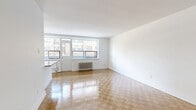 Located at 2220 Weston Rd in Toronto's Weston neighbourhood, this one-bedroom, one-bathroom unit offers a well-organized layout across a single floor. Gleaming parquet flooring runs consistently throughout the living spaces and bedroom, lending warmth and a classic character to the interior. Crisp white walls and clean baseboards create a bright, neutral backdrop throughout.

The open living room is generously proportioned, featuring large windows that draw in natural light and offer views of the surrounding neighbourhood. A cast-iron radiator provides efficient heating. The kitchen is designed in a galley configuration, finished with white cabinetry, dark countertops, a herringbone tile backsplash, stainless steel appliances, and light tile flooring — making efficient use of the available space.

The bedroom is a comfortable size, featuring its own window with a radiator beneath it and a double-door closet for ample storage. The bathroom is finished with crisp white subway tile surrounding a soaker tub and shower combination, complemented by a white vanity with an undermount sink.

A standout feature is the private balcony, enclosed with a glass railing, offering open views of the surrounding residential streetscape and greenery — an ideal outdoor extension of the living space.