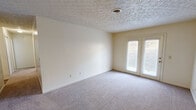 Located at 303 Far Side Dr in Rogersville, Tennessee, this single-floor, 2-bedroom, 1-bathroom home offers a functional and straightforward layout. The combined living room and kitchen area forms the heart of the home, with the living space featuring neutral carpet, textured ceilings, and a set of French doors that fill the room with natural light. The galley-style kitchen is efficiently designed with white cabinetry lining both sides, ample counter space, wood-look flooring, and white appliances including an electric range and refrigerator. A hallway connects the main living areas to the private quarters. Both bedrooms are carpeted and feature textured ceilings, neutral walls, and individual closets with bifold doors and built-in shelving rods for storage. The primary bedroom is comfortably sized and includes a dedicated closet. The bathroom is clean and functional, featuring a soaking bathtub with surround walls and wood-look flooring. A separate closet provides additional storage. The home's consistent neutral color palette throughout creates a cohesive, move-in ready environment suited for comfortable everyday living.