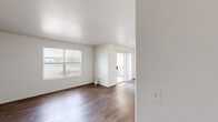 Located at 1349 W Horizon Ridge Pkwy in Henderson, Nevada, this single-floor, 3-bedroom, 2-bathroom home offers a well-organized and functional layout. The open living area features rich, dark wood-style flooring, clean white walls, and a textured ceiling, with large windows allowing natural light to fill the space. A sliding glass door connects the living area to an outdoor space beyond. The kitchen is thoughtfully designed with warm honey-toned wood cabinetry, ample upper and lower storage, a peninsula with a built-in sink and counter seating, and white appliances including a refrigerator, electric range, and microwave. Track lighting overhead adds a practical touch. The primary bedroom is generously proportioned and includes a dedicated walk-in closet fitted with wire shelving and dual hanging rods for organized storage. The two additional bedrooms feature soft carpeting and windows that bring in natural light, making them well-suited for various uses. The bathrooms are cleanly finished, with one featuring wood-toned cabinetry, a single-basin vanity with a stone-look countertop, and a tub/shower combination with chrome fixtures. Overall, the home presents a neutral, move-in-ready aesthetic throughout.