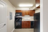 Located at 2900-2915 Seay St in Alexandria, Virginia, this 2-bedroom, 1-bathroom residence offers a practical and comfortable single-floor layout. The combined living and dining area is bright and welcoming, featuring light wood-style luxury vinyl plank flooring and neutral walls that create an airy, open atmosphere. A sliding glass door fills the space with natural light and provides access to a private balcony with outdoor views. The kitchen is efficiently designed with warm cherry-toned cabinetry, light countertops, and a full suite of black appliances, including a range, built-in microwave, dishwasher, and refrigerator. Both bedrooms are carpeted and finished with neutral tones, offering a cozy retreat. The primary bedroom is generously sized and features multiple closets, while the second bedroom includes a window that invites natural light. In total, the residence offers an impressive six closets, providing exceptional storage throughout. The full bathroom includes a tiled tub-and-shower combination with a decorative accent border, a wood-toned vanity with an integrated sink, and tile flooring. The entrance leads conveniently into the main living area, creating a smooth and intuitive flow throughout the home.