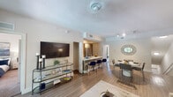 This thoughtfully designed single-floor residence offers a bright, open-concept layout that seamlessly connects the living, dining, and kitchen areas. The living room features warm wood-look flooring, a ceiling fan, and track lighting, creating a comfortable and versatile space for everyday living and entertaining. A convenient closet is tucked just off the main living area for additional storage.

The kitchen is well-equipped with stainless steel appliances including a side-by-side refrigerator, electric range, and microwave, complemented by light wood cabinetry, quartz countertops, and a peninsula with bar seating. An in-unit washer and dryer is conveniently located just off the kitchen. The dining area sits adjacent, providing a cohesive flow throughout the main living space.

The bedrooms are carpeted and filled with natural light from multiple windows, each featuring ceiling fans and ample closet space, including walk-in closets in select rooms. The bathrooms are clean and functional, featuring a tiled soaking tub and shower combination. Neutral tones and warm lighting throughout the residence create a calm, inviting ambiance that is both modern and comfortable.