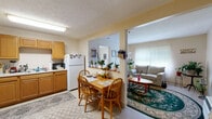 Located at 1245 Centre Pkwy in Lexington, Kentucky, this single-floor, 2-bedroom, 1-bathroom home offers a practical and efficiently arranged layout. The living room serves as a welcoming common area, featuring light-toned walls, a textured ceiling, and windows fitted with horizontal blinds that allow natural light to filter in. A wall-mounted HVAC unit provides climate control, and the space comfortably accommodates seating and a central coffee table area.

The kitchen is adjacent to the living space and is outfitted with warm wood-toned cabinetry, a double-basin sink, an electric range, and a full-sized refrigerator. Light-colored countertops and tile-style flooring contribute to a clean, functional workspace.

The primary bedroom benefits from dual windows dressed with curtain panels, bringing in natural light and a sense of openness. Both bedrooms feature neutral wall colors and carpeted flooring, providing a quiet and comfortable retreat.

A narrow hallway connects the bedroom area to the full bathroom and features built-in closets on both sides, offering practical storage solutions within the compact footprint. The bathroom includes a vanity with a wall mirror and standard fixtures.

Overall, this home presents a straightforward, functional living environment suited for everyday comfort in a single-story setting.
