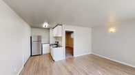 Located in the West Seattle neighborhood at 4307 30th Ave SW, this one-bedroom, one-bathroom unit offers a thoughtfully organized layout across a single floor. The open living area is bright and welcoming, featuring light wood-style flooring and large windows fitted with vertical blinds that invite generous natural light and offer views of the surrounding greenery. Baseboard heating ensures year-round comfort throughout the space.

The kitchen is efficiently designed with crisp white cabinetry, dark granite-style countertops, and stainless steel appliances including a full-size refrigerator and an electric range with oven. The layout maximizes functionality, providing ample cabinet and counter space for everyday cooking needs.

The bedroom is carpeted for added warmth and comfort, with a window that brings in natural light while maintaining privacy. The bathroom features a classic pedestal sink, a mirrored medicine cabinet, and clean, neutral finishes that contribute to a simple and tidy aesthetic.

Throughout the unit, neutral wall tones and consistent finishes create a cohesive, understated ambiance. The space is ideal for those seeking a clean, move-in-ready home in a convenient Seattle location.