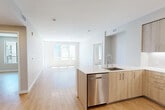 This well-designed two-bedroom, two-bathroom unit on Rambla Place in Santa Clara, CA offers a thoughtfully arranged single-floor layout with a clean, modern aesthetic. Light wood-tone flooring runs continuously throughout the space, complementing the bright white walls and creating a cohesive, contemporary feel.

The open-concept kitchen and living area serves as the heart of the unit. The kitchen is outfitted with light wood cabinetry extending to the ceiling, white subway tile backsplash, stainless steel appliances including a French door refrigerator, electric range, built-in microwave, and dishwasher. A peninsula with a white quartz countertop and undermount sink provides additional workspace and separates the kitchen from the living area, which benefits from large windows that draw in abundant natural light.

A hallway connects the main living area to the two bedrooms, each featuring light wood flooring, neutral warm-toned walls, and windows with views of the surrounding urban exterior. The spacious primary bedroom receives generous natural light through wide sliding windows. Both bedrooms include dedicated closets for storage.

The bathrooms feature light wood vanities with white countertops, tiled tub-shower combinations, and small windows providing natural ventilation and light.
