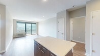 Located at 293 Polifly Rd in Hackensack, NJ, this well-appointed two-bedroom, two-bathroom residence offers a thoughtfully designed single-floor layout with modern finishes throughout. Warm hardwood flooring flows through the main living areas, complementing the clean, contemporary aesthetic of the space.

The open-concept kitchen is a standout feature, showcasing rich dark wood cabinetry with sleek hardware, white quartz countertops, a tile backsplash, and a full suite of stainless steel appliances including a refrigerator, range, microwave, and dishwasher. A generous kitchen island provides additional prep space and seating potential.

The combined living and dining area is bright and airy, highlighted by large sliding glass doors that open to a private balcony offering open views of the surrounding cityscape, flooding the space with natural light.

The primary bedroom is spacious and includes a large window with outdoor views, hardwood flooring, and access to a well-organized walk-in closet with wire shelving. The en-suite bathroom features marble-style tile flooring, a wide vanity with wood cabinetry, and a separate shower area. The second bedroom is comfortably sized with hardwood floors and ample natural light. A second full bathroom includes a tub-shower combo, wood vanity, and large-format tile flooring.