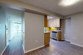 Located at 9739 Woods Dr in Skokie, IL, this well-designed one-bedroom, two-bathroom residence offers a thoughtfully organized single-floor layout. The open living and dining area is anchored by wide plank hardwood-style flooring and floor-to-ceiling glass sliding doors that flood the space with natural light and provide direct access to a private balcony with outdoor views. The galley-style kitchen is a functional highlight, featuring granite countertops, a decorative tile backsplash, light maple cabinetry extending to the ceiling, stainless steel appliances including a dishwasher and microwave, a gas cooktop, and track lighting overhead. A pass-through design connects the kitchen seamlessly to the dining and living areas. The spacious primary bedroom is carpeted for comfort and includes its own access to the balcony via large sliding glass doors, offering additional natural light and views. Two full bathrooms serve the residence, one featuring warm tile flooring and a wood-toned vanity. Additional conveniences include in-unit laundry, three closets for ample storage, and two hallways connecting the various rooms. The overall ambiance is clean, neutral, and modern, making this a highly functional and well-lit home.