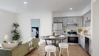 Located on Van Nuys Boulevard in Los Angeles, this thoughtfully designed 3-bedroom, 2-bathroom residence offers a clean, modern aesthetic across a single floor. Light wood flooring runs throughout, tying together a bright, cohesive interior bathed in natural light.

The open-concept living, dining, and kitchen area forms the heart of the home. The kitchen is well-appointed with gray shaker-style cabinetry, quartz countertops, and a full suite of stainless steel appliances including a refrigerator, range, and dishwasher. The adjacent dining area comfortably accommodates a round table, while the living room offers access to an outdoor balcony, bringing in generous natural light.

The spacious primary bedroom features large windows with blinds and easy access to a dedicated closet. Two additional bedrooms are bright and well-proportioned, each with windows that invite natural light. Both bathrooms are finished in a clean, contemporary style with white shaker vanities, quartz countertops, large mirrors, and tub-shower combinations. White walls and recessed lighting throughout the home create a fresh, airy ambiance that feels both functional and inviting.