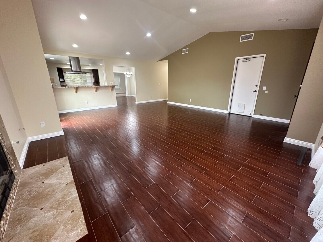 Living room looking to kitchen and hallway to bedrooms. Door on right is to washer/dryer & garage - 11008 Twin Pond Ter