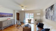 Unit 321A at Donaldson Park Apartments is a single-floor residence designed for comfortable everyday living. The living room serves as the heart of the unit, featuring warm hardwood flooring, a ceiling fan, and a sliding glass door that opens onto a private balcony overlooking the surrounding grounds, allowing natural light to fill the space. A wall-unit air conditioner provides climate control, complementing the baseboard heating found throughout.

The kitchen is functionally appointed with warm-toned wood cabinetry, dark granite-style countertops, and stainless steel appliances including a gas range, over-the-range microwave, dishwasher, and refrigerator. Tile flooring and a window above the sink add practicality and light to the space.

Two bedrooms offer hardwood flooring, ceiling fans, and windows that bring in natural light. Each room includes closet storage, and wall-unit air conditioners ensure year-round comfort. The bedrooms maintain a calm, neutral palette throughout.

The full bathroom features a wood-framed vanity with a white countertop, a tiled tub-shower combination, and a mirrored medicine cabinet, providing a clean and functional layout. Overall, the unit presents a straightforward, well-maintained living environment.