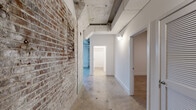 Located in Memphis, TN, this 1-bedroom, 1-bathroom unit at Kismet 10 offers a compelling blend of industrial character and modern functionality. The space is defined by its raw, historic architectural elements — most notably the exposed brick walls and polished concrete floors that carry throughout, creating a cohesive, loft-style aesthetic. Overhead, exposed ductwork and structural piping add to the industrial ambiance, while crisp white walls provide a clean contrast.

The open living area is generously proportioned, featuring a large window that brings in natural light and offers exterior views. The combined dining and kitchen area is well-equipped with white cabinetry, granite countertops, full appliances including a refrigerator, range, and built-in microwave, alongside industrial-style windows that brighten the space.

The bedroom is a comfortable, well-sized retreat with a ceiling fan and direct access to the hallway and closet areas. Two closets with wire shelving systems provide ample storage. The bathroom includes a tiled tub/shower combo, recessed lighting, and clean, modern fixtures.

A dedicated laundry room houses a full-size washer and dryer. A utility room and two hallways round out the functional layout, making this unit as practical as it is visually distinctive.