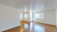Located at 348 Estabrook St in San Leandro, California, this single-floor residence offers a clean, modern interior with a cohesive design throughout. Warm hardwood-style flooring flows seamlessly across all living areas, complementing the crisp white walls and creating a bright, welcoming atmosphere.

The open living and dining area is generously proportioned, bathed in natural light from multiple large windows that frame views of the surrounding neighborhood. Ceiling fans provide year-round comfort in both the living space and the bedroom.

The galley-style kitchen is well-appointed with white cabinetry, dark countertops, a double-basin sink, and a full suite of stainless steel appliances, including a refrigerator and range. Pendant lighting adds a contemporary touch overhead.

The bedroom is a comfortable, light-filled retreat featuring a wide mirrored sliding-door closet that enhances the sense of space. A window overlooks greenery outside, adding a pleasant natural element to the room. In-unit laundry — a stacked washer and dryer — is conveniently accessible from the bedroom area.

The bathroom is finished in clean, all-white tones, featuring a vanity with an undermount sink, a full bathtub with shower, and a small window for natural ventilation. Every detail of this residence reflects a tidy, functional, and move-in-ready design.