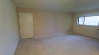 Located at 315 A, this single-floor space presents a straightforward and functional layout designed for comfortable everyday living. The main living area is finished with wall-to-wall neutral-toned carpeting that lends a soft, understated feel underfoot. The walls are painted in a warm beige tone, creating a simple and cohesive aesthetic throughout the room. A standard entry door provides direct access to the living space, positioned along one wall and complemented by clean white trim and baseboards that frame the room neatly. Electrical outlets and light switch plates are conveniently placed along the walls. The ceiling is smooth and uniform, maintaining a clean overhead appearance. The open nature of the main room allows for flexible furniture arrangement, accommodating a variety of living configurations. The overall ambiance of the space is calm and neutral, offering a blank canvas well-suited for personalization. The single-floor layout ensures easy accessibility and straightforward navigation throughout the unit. The space is practical and move-in ready, appealing to those seeking a no-frills, functional living environment.