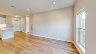 This thoughtfully designed one-bedroom, one-bathroom residence at 59 Mill St in Woburn, Massachusetts offers a clean, modern aesthetic with high-quality finishes throughout. The open-concept layout seamlessly connects the kitchen, dining, and living areas, creating a bright and functional living space. Light hardwood flooring flows throughout the entire unit, complemented by recessed lighting and neutral wall tones that enhance the airy atmosphere.

The kitchen is a standout feature, showcasing crisp white shaker cabinetry, white subway tile backsplash, light quartz countertops, and a central island that provides additional prep and seating space. Stainless steel appliances, including a refrigerator, electric range, and over-the-range microwave, complete the contemporary kitchen.

The bedroom is well-proportioned, featuring large windows that invite ample natural light and offer views of the surrounding neighborhood. The space is serviced by four closets, providing exceptional storage throughout the unit.

The full bathroom is finished with classic white subway tile surrounding a soaking tub and shower combination, brushed nickel fixtures, and tile flooring. Additional conveniences include a dedicated laundry area, a utility room, and a hallway connecting all spaces efficiently. The overall design is clean, modern, and move-in ready.