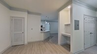 This contemporary residence boasts a thoughtfully designed open floor plan, seamlessly connecting living spaces. The interior is characterized by neutral tones and abundant natural light, enhanced by modern ceiling fans and recessed lighting. Wood-look flooring extends throughout, creating a cohesive aesthetic. The kitchen area includes a breakfast bar, while multiple rooms offer versatile living options. A well-appointed bathroom features a tub-shower combination with stylish tiling. The attached garage provides convenient storage, and the fenced backyard offers privacy amidst a wooded setting, perfect for outdoor enjoyment.