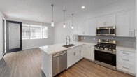 Located at 4868 Cypress St in Montclair, California, this single-floor unit offers a thoughtfully designed layout with modern finishes throughout. The kitchen serves as a standout feature, showcasing crisp white shaker cabinetry, light gray subway tile backsplash, and a full suite of stainless steel appliances including a gas range, microwave, dishwasher, and refrigerator. A peninsula with a single-basin undermount sink and white quartz-style countertops provides additional prep space, while three stylish pendant lights hang overhead, adding both functionality and visual appeal. Wood-look plank flooring runs through the kitchen and living areas, lending warmth and continuity to the open-concept space. Natural light flows in through windows dressed with horizontal blinds, creating a bright and airy atmosphere. The bedrooms are finished with neutral wall-to-wall carpeting and offer windows that bring in additional daylight. The bathroom is clean and efficiently appointed, featuring a white vanity with under-cabinet storage, a large mirror, and a shower-tub combination, all set on wood-look plank flooring. The overall design emphasizes a fresh, contemporary aesthetic with a neutral color palette that makes the space feel open, inviting, and move-in ready.