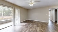 Located at 7325 Goldenpointe Boulevard in Orlando, Florida, this single-floor, three-bedroom, two-bathroom home offers a well-organized and functional layout. The open-concept living, dining, and kitchen area serves as the heart of the home, featuring rich wood-look flooring and a ceiling fan with light fixture that enhances airflow and brightness. Large sliding glass doors with vertical blinds connect the living space to a private balcony, filling the interior with natural light.

The kitchen is a standout feature, equipped with stainless steel appliances including a refrigerator, range, and microwave. White cabinetry pairs elegantly with granite-style countertops, and a peninsula with a built-in sink and pendant lighting above provides additional workspace and casual dining opportunities.

Both bathrooms are finished with white vanity cabinetry, granite-style countertops, and tub-shower combinations with tile surrounds, all set on wood-look flooring. The three bedrooms feature plush carpeting, ceiling fans, and natural light from windows with blinds. Five closets throughout the home ensure ample storage. Additional conveniences include a dedicated laundry area and a utility room, rounding out this practical and comfortable Orlando residence.