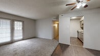 This 2-bedroom, 2-bathroom residence offers a practical and comfortable single-floor layout designed to maximize everyday livability. The open living area features a combination of plush carpeting and dark hardwood-style flooring, with a ceiling fan overhead and a sliding glass door that invites natural light and outdoor access. A side window near the entryway further brightens the space, which also includes a dedicated closet near the front door for added convenience.

The kitchen is efficiently designed with granite-style countertops, tile backsplash, taupe cabinetry, and dark appliances including a refrigerator and dishwasher, all set on durable hardwood-style flooring.

Both bedrooms are carpeted and well-lit by windows with blinds. The primary bedroom offers a generous footprint, a ceiling fan with light, and a closet with sliding doors. The second bedroom is comfortable in size with its own window. A walk-in closet with dual shelving systems provides ample storage. Each bathroom is clean and functional, featuring a tiled tub-shower combination and hardwood-style flooring. Textured ceilings are present throughout, adding a classic residential character to the overall space.