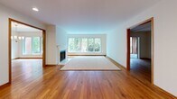 This well-appointed single-floor home in Madison, Wisconsin offers a thoughtfully designed layout with three bedrooms, three bathrooms, and generous living space throughout. Warm hardwood flooring flows through the main living areas, complemented by rich wood trim and oak doors that lend a cohesive, classic character to the interior.

The spacious living room is a standout feature, anchored by a fireplace and framed by large windows that flood the space with natural light and offer serene views of the surrounding wooded landscape. The kitchen is equipped with solid oak cabinetry, white countertops, and a stainless steel refrigerator, opening conveniently to a dedicated dining area. A separate formal dining room provides additional flexibility for entertaining.

The primary bedroom is generously sized, featuring plush carpeting, a ceiling fan, and a wide window overlooking the trees. It is complemented by a private en-suite bathroom with a walk-in shower, a wide vanity with ample drawer storage, and tile flooring. Additional bathrooms include a full tub-shower combo with white tile surround. A walk-in closet with built-in shelving and hardwood floors offers excellent storage.

A screened porch with brick exterior walls and lush wooded views provides a peaceful outdoor retreat. The home also includes a utility room and multiple hallways connecting the well-organized floor plan.