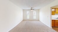 Located at 901 Rob Roy Ct in West Columbia, SC, this single-floor, one-bedroom, one-bathroom unit offers a practical and comfortable layout ideal for individuals or couples. The living room features neutral-toned carpet, clean white walls, and a ceiling fan with a light fixture, creating a bright and airy atmosphere. Natural light filters in through multiple windows, enhancing the open feel of the space. The bedroom is generously sized, featuring soft carpeting, a ceiling fan, and an impressive double set of bifold closet doors that provide abundant storage. Additional windows in the bedroom allow for pleasant natural light and outdoor views. The galley-style kitchen is well-appointed with warm oak cabinetry lining both walls, a light-toned countertop, a stainless steel sink, and white appliances including an electric range and refrigerator. Light wood-style flooring adds warmth and is easy to maintain. The bathroom is clean and functional, featuring a combination tub and shower unit with built-in shelving, complemented by neutral wall tones and chrome fixtures. Throughout the unit, a consistent neutral color palette and textured ceilings contribute to a cohesive, move-in-ready aesthetic.