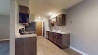Located at 3313 W Mount Hope Ave in Lansing, Michigan, this single-floor unit offers a thoughtfully designed layout with a practical mix of modern finishes and comfortable living spaces. The galley-style kitchen is a standout feature, showcasing dark espresso cabinetry paired with light granite-style countertops, stainless steel appliances including a refrigerator, gas range, dishwasher, and built-in microwave, all set atop durable wood-look vinyl plank flooring. Ample upper and lower cabinet storage ensures functionality throughout. The open living and dining areas continue the wood-look flooring and are brightened by large windows dressed with vertical blinds, allowing natural light to fill the space. A ceiling fan adds comfort to the main living area. The bedrooms feature plush carpeting, neutral-toned walls, and generous closet space, with one bedroom showcasing a walk-in style closet with a rod system. The bathroom is clean and straightforward, equipped with a full tub-shower combo and classic white fixtures. Baseboard heating runs throughout, and the textured ceilings in the living areas add a classic touch. The overall aesthetic is clean, updated, and move-in ready.