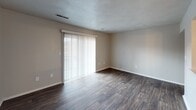 Located at 4302 Plantation Rd NE in Roanoke, Virginia, this single-floor residence offers a well-organized layout designed for comfortable everyday living. The main living areas feature rich, dark hardwood-style flooring that flows seamlessly throughout, complemented by neutral-toned walls that create a clean, versatile backdrop. Large sliding glass doors dressed with vertical blinds allow generous natural light to fill the living space while providing direct views of the outdoors.

The kitchen is equipped with white cabinetry offering ample storage, dark granite-style countertops, a tile backsplash, stainless steel appliances including an electric range and dishwasher, and a double-basin stainless steel sink — providing a practical and functional cooking environment.

The bedrooms are finished with wall-to-wall carpeting in warm neutral tones, each featuring windows with blinds that invite natural light while maintaining privacy. The bathroom is outfitted with a full tub and shower combination, a single-sink vanity, and a mirrored medicine cabinet, all finished in crisp white tones with wood-style flooring.

Overall, this residence presents a straightforward and functional design with consistent finishes throughout, offering a comfortable and move-in ready living environment in a convenient Roanoke location.