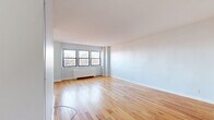 Located at 243 S Harrison St in East Orange, NJ, this well-appointed one-bedroom, one-bathroom unit offers a thoughtfully designed layout across a single floor. The open living area is bright and welcoming, featuring warm hardwood flooring that flows throughout and multiple windows that invite generous natural light and outdoor views of the surrounding neighborhood. The clean white walls and simple architectural lines create a calm, neutral backdrop well-suited for a variety of living arrangements. The galley-style kitchen is both functional and stylish, outfitted with dark espresso cabinetry, granite countertops, stainless steel appliances including a gas range and refrigerator, and light tile flooring that contrasts neatly with the rich cabinetry. A hallway connects the main living spaces to the generously sized bedroom, which features the same warm hardwood floors, a large window, and the convenience of dual closets providing ample storage. The bathroom is a standout feature, clad in large-format marble-look tile that lines the walls of the tub surround, complemented by a soaking tub and a window for natural ventilation. A dedicated closet and entryway hallway complete the layout, contributing to an organized and efficient use of space throughout this clean, move-in ready unit.