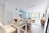 Located at 2000 Stirling Rd in Hollywood, FL, this single-story, 3-bedroom, 2-bathroom residence offers a thoughtfully designed open-concept layout. The entry foyer features rich hardwood-style flooring and a striking tropical botanical wall mural, setting a vibrant tone upon arrival. The kitchen is appointed with white shaker cabinetry, granite countertops, a subway tile backsplash, stainless steel appliances, and a breakfast bar with seating. It flows seamlessly into the combined dining and living area, where a teal accent wall, ceiling fan, and sliding glass doors to the patio fill the space with natural light and outdoor greenery views. The spacious primary bedroom features a bold blue accent wall, ceiling fan, and ample natural light. Additional bedrooms are bright and well-sized, each with closet storage. The bathrooms are finished with granite vanities, white cabinetry, illuminated mirrors, and tiled tub-shower combinations. A dedicated laundry room, pantry, and utility room provide practical convenience. The patio extends the living space outdoors, completing this well-rounded and stylishly finished residence.