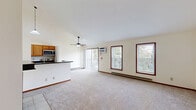Located at 7609 Radcliffe Dr in Madison, WI, this 2-bedroom, 1-bathroom single-floor home offers a thoughtfully designed layout with standout architectural details. The open-concept living and kitchen area immediately impresses with soaring vaulted ceilings and a ceiling fan, creating an airy, expansive atmosphere. A tile-surround fireplace with a sleek dark mantle serves as the focal point of the living room, which features plush carpeting and warm wood trim throughout.

The kitchen is well-appointed with light oak cabinetry, dark granite countertops, stainless steel appliances including a refrigerator, electric range, and microwave, along with a central island and pendant lighting. Tile flooring transitions seamlessly from the kitchen into the entryway.

The spacious primary bedroom offers a generous walk-in closet and a large window that frames views of mature greenery. The second bedroom is bright and comfortable, with its own closet and natural light. Multiple windows fitted with blinds bring the outdoors in throughout the home.

The bathroom is clean and functional, featuring a walk-in shower, a wide vanity with ample cabinet storage, and a convenient in-unit stacked washer and dryer. Baseboard heating is present throughout, ensuring year-round comfort in this well-maintained Madison residence.
