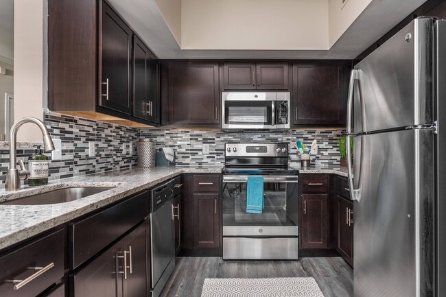 Upgraded Kitchen with Hardwood Floors and Designer Backsplash - Oxmoor Apartments