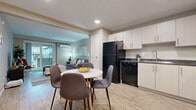 Located at 350 Bobolink Ridge in Ottawa's Barrhaven community, this 2-bedroom, 2-bathroom unit offers a thoughtfully designed single-floor layout with consistent modern finishes throughout. Light wood-look flooring runs seamlessly across all rooms, creating a cohesive and airy feel.

The kitchen features crisp white cabinetry, dark granite-style countertops, black appliances including a full-size refrigerator and electric range, and recessed lighting — all open to a dedicated dining area. The living room is generously sized, offering large sliding patio doors that fill the space with natural light and provide views of the surrounding neighbourhood, complemented by a wall-mounted mini-split unit.

Both bedrooms are comfortably proportioned, with large windows overlooking the exterior and warm neutral tones on the walls. The spacious primary bedroom benefits from ample natural light and direct access to one of the two bathrooms, which features a light wood vanity with dark countertop and a full tub-shower combo. The second bathroom mirrors this refined aesthetic.

A dedicated in-unit laundry area with side-by-side top-load washer and dryer adds everyday convenience. A closet provides additional storage, completing this practical and modern home.