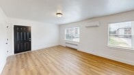 Located at 1823 Griswold Dr in Fort Wayne, Indiana, this updated 2-bedroom, 1-bathroom unit offers a clean, modern aesthetic with a practical single-floor layout. Light wood vinyl flooring runs consistently throughout the home, complementing the crisp white walls and creating a bright, cohesive feel.

The open living room provides a comfortable gathering space, featuring a wall-mounted mini-split system, a baseboard radiator, and a window that brings in natural light. It flows directly into the kitchen, which is outfitted with white shaker cabinets, a gray tile backsplash, stainless steel appliances including a refrigerator, electric range, and over-the-range microwave, and a sink with a modern faucet.

Both bedrooms are well-proportioned and feature ceiling fans with light fixtures, closets, and windows with views of the surrounding neighborhood. The primary bedroom is generously sized and includes its own closet. A connecting hallway links the bedrooms to the rest of the unit.

The bathroom is finished with large-format marble-look tile surrounding the tub and shower, complemented by matte black fixtures and a window for natural ventilation. Clean lines and neutral tones throughout give this home a move-in-ready appeal suited for a variety of lifestyles.