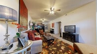 Located at 401 W Covell Rd in Edmond, Oklahoma, this well-designed 2-bedroom, 3-bathroom residence offers a comfortable and functional single-floor layout. The open-concept living area greets you upon entry, featuring vaulted ceilings, plush carpet flooring, and ceiling fans that enhance airflow and ambiance. Large windows allow generous natural light to fill the space, offering views of the surrounding greenery. The kitchen is a standout feature, boasting rich dark wood cabinetry, granite-style countertops, hardwood-style flooring, a central island with bar seating, and a full suite of black appliances including a dishwasher, range, microwave, and refrigerator — all under pendant lighting. The primary bedroom is generously proportioned, with carpet flooring, a window with outdoor views, and access to a spacious walk-in closet equipped with wire shelving. The second bedroom also includes a closet with built-in shelving. Three bathrooms serve the residence, with at least one featuring a tub-shower combo with sliding glass doors, wood-style flooring, and cabinetry for storage. A dedicated hallway connects the rooms, providing a logical and efficient flow throughout this thoughtfully laid-out home.