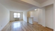 Located at 112 Hoyt St in Stamford, Connecticut, this 2-bedroom, 1-bathroom residence offers a well-designed single-floor layout that balances functionality with a clean, modern aesthetic. The living area is bright and open, featuring gleaming hardwood floors that extend throughout the space, reflecting natural light that pours in through a large window. Crisp white walls and simple, uncluttered lines give the interior a fresh and airy feel. A defining architectural feature is the pass-through kitchen, which opens to the living area via a half-wall counter — creating a connected flow between the two spaces while maintaining a sense of separation. The kitchen is efficiently laid out with overhead cabinetry and ample counter space. Structural ceiling beams add a subtle architectural detail overhead. A baseboard radiator provides heating, and the overall layout makes practical use of every square foot. The two bedrooms offer comfortable retreats, while the single bathroom rounds out the home. The neutral color palette and hardwood flooring throughout create a cohesive, move-in-ready environment well-suited for a variety of living arrangements in the heart of Stamford, CT.