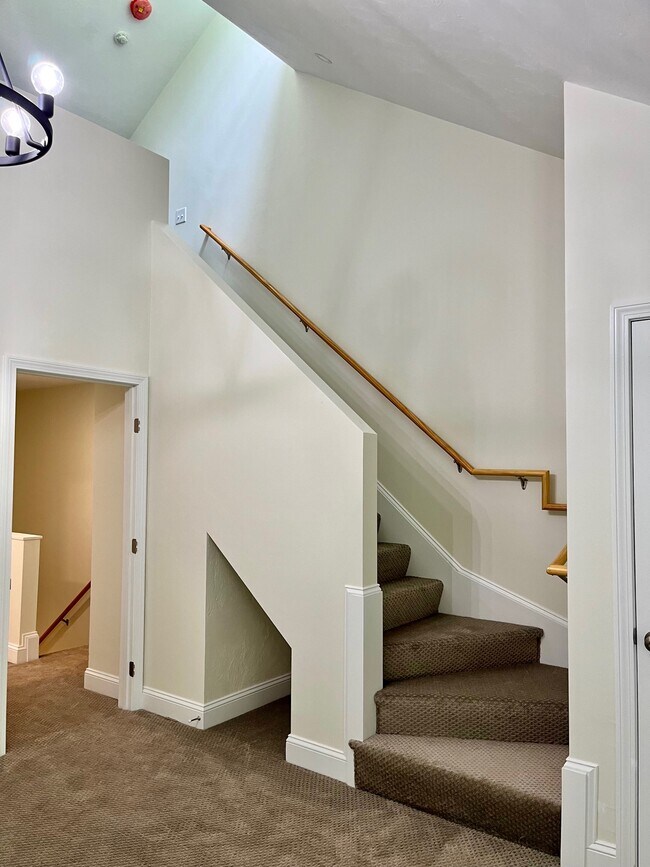 Luminoso y soleado dormitorio principal GRANDE con techos abovedados, lámpara de araña y escalera al loft. - 326 Sterling St