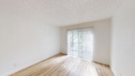 Located at 710 N 46th St in Killeen, Texas, this single-floor, one-bedroom, one-bathroom unit offers a thoughtfully designed layout with a clean, modern aesthetic throughout. Light wood-look flooring flows seamlessly across all rooms, complemented by crisp white walls and textured ceilings that add depth to the space.

The combined kitchen and living area is a standout feature, anchored by a sleek peninsula with granite countertops and a matte black faucet. The kitchen is equipped with stainless steel appliances, white cabinetry, and a striking wood slat accent panel above the counter that adds a warm, contemporary touch. Recessed lighting brightens the space effectively.

The living area benefits from a large sliding glass door dressed with vertical blinds, inviting an abundance of natural light and providing access to a private balcony. From the balcony, residents enjoy views of mature, canopied trees and the surrounding community grounds, which include a playground area.

The bedroom is a comfortable, well-lit retreat featuring a ceiling fan with light fixture, a window with blinds, and ample wall space. The bathroom is neatly appointed with a white vanity, granite countertop, matte black fixtures, a large mirror, and a full tub-shower combination. A dedicated closet completes this efficiently organized unit.