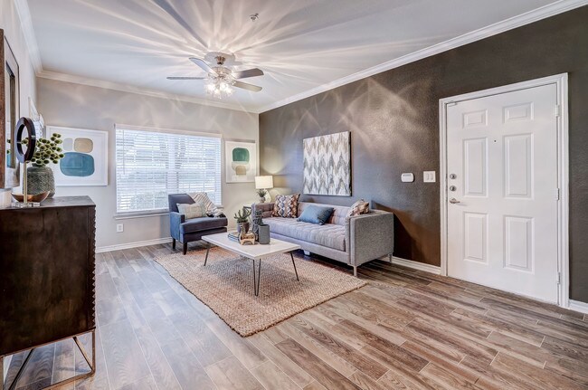 Sala de estar amplia con pisos de madera noble y ventiladores de techo - Parkways on Prairie Creek