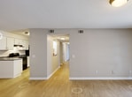 Located at 205 Old Hull Rd in Athens, Georgia, this single-story home offers a practical and well-organized layout with three bedrooms, two bathrooms, and a combined kitchen and living area. Light wood-style flooring flows consistently throughout the home, creating a clean and cohesive aesthetic complemented by neutral taupe walls and white trim.

The open living room is generously proportioned, filled with natural light through a large sliding glass door fitted with vertical blinds that provide views of the surrounding greenery. The galley-style kitchen is efficiently designed with white cabinetry, dark granite-style countertops, black appliances including a gas range and refrigerator, a stainless steel sink, and a louvered pantry door offering additional storage.

The three bedrooms are comfortably sized, with the primary bedroom offering notable space. Each bedroom features light flooring, neutral walls, and closets with double bi-fold doors. Several rooms benefit from windows with blinds that bring in natural light and outdoor views of mature trees.

Both bathrooms are consistent in design, each featuring a tub-shower combination, light wood-style flooring, dark countertop vanities, and a clean, functional layout. A hallway connects the bedrooms and bathrooms, keeping the floor plan well-organized. The textured ceilings appear throughout the home, adding a subtle architectural detail.