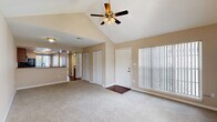 Located at 3453 Timber Run Dr. in Valrico, FL, this 2-bedroom, 3-bathroom single-floor home offers a thoughtfully laid-out living space with standout architectural details. The living and dining areas are anchored by soaring vaulted ceilings and a ceiling fan with light fixture, creating an open and airy atmosphere. Large windows dressed with vertical blinds invite natural light throughout, while a front entry door with a wood-toned mat area adds a welcoming touch. Built-in closets provide convenient storage directly off the main living area.

The kitchen is well-appointed with rich wood cabinetry, granite-style countertops, a tile backsplash, and a full suite of black appliances including a refrigerator, range, dishwasher, and over-the-range microwave, all set atop warm hardwood-style flooring.

Both bedrooms feature plush carpeting, ceiling fans, and generous closet space. The primary bedroom benefits from vaulted ceilings and a large window offering outdoor views, while the second bedroom is comparably bright and comfortable. The three bathrooms are clean and functional, each featuring a tub-shower combination. A balcony rounds out the home, providing an outdoor retreat.