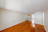 Located at 135 Chestnut St in Foxborough, MA, this single-floor, 2-bedroom, 1-bathroom unit offers a practical and comfortable layout. The living room is a standout space, featuring rich hardwood floors that run throughout and a distinctive white painted brick accent wall that adds texture and character. The open sightline from the living area into the kitchen creates a connected, spacious feel. A large window with vertical blinds allows generous natural light and outdoor views.

The kitchen is well-equipped with warm oak cabinetry extending to the ceiling, a tile backsplash, a gas range, dishwasher, and a separate refrigerator. Light ceramic tile flooring and windows with outdoor views make the kitchen bright and functional. A door in the kitchen provides direct exterior access.

The two bedrooms continue the hardwood flooring theme, with the primary bedroom offering a large window overlooking the outdoors. The second bedroom is a comfortable, well-proportioned space with clean, neutral walls. Five closets throughout the unit provide exceptional storage.

The bathroom features classic white subway tile surrounding a full tub/shower, complemented by light neutral walls and tile flooring. A hallway connects the rooms efficiently, rounding out this well-organized, move-in ready unit.